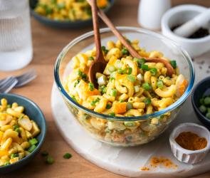 Curry Nudelsalat in einer Glasschale.