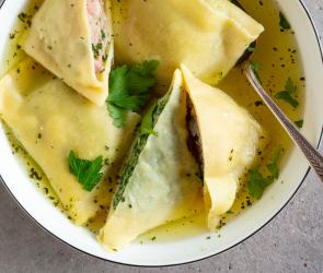 Maultaschen in Brühe mit Petersilie garniert.