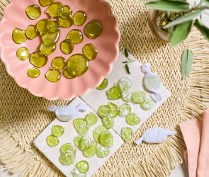 Grüne Salbeibonbons in einer rosa Schale.