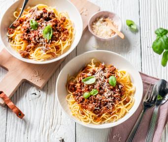 Einfache Spaghetti Bolognese auf Tellern garniert mit Basilikum