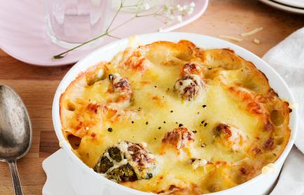 Bunter Gemüseauflauf in einer Auflauform auf einem Tisch.