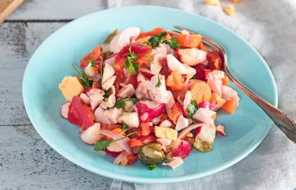 Bunter Käse-Wurst-Salat auf einem Teller mit Gabel.