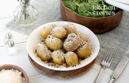 Dampfkartoffeln (Cacio e Pepe) mit Spinatsalat in zwei Schalen.
