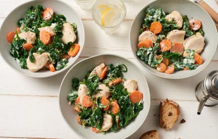 Hähnchenbrust-Medaillons mit Spinat auf drei Tellern.