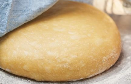 Hefeteig süß wird mit einem Tuch abgedeckt.