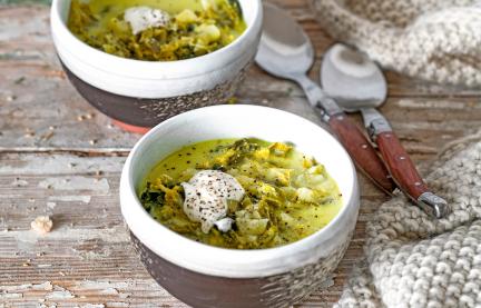 Käse-Wirsing-Suppe in zwei Schalen auf einem Tisch.