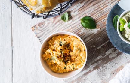 Mediterraner Brotaufstrich in Schälchen mit Laugenbrötchen.