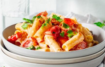 Nudeln mit Sauce und Petersilie auf drei tiefen Tellern