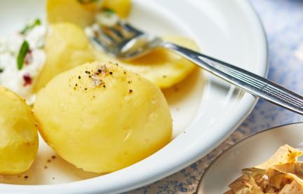 Pellkartoffeln auf einem Teller mit Petersilie garniert.