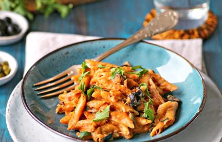 Vollkornnudeln mit Thunfischsoße auf einem Teller.