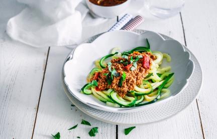 Zucchininudeln auf Teller mit Bolognesesauce