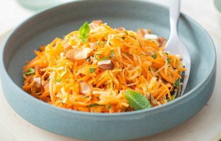 Karotten-Apfel-Salat mit Granola in großer Schale.