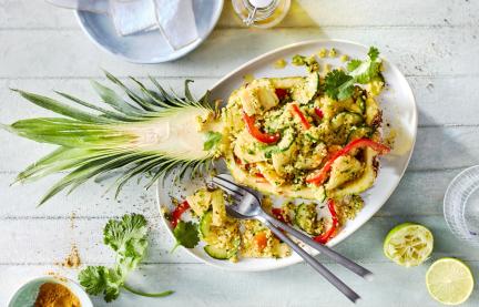 Ananas-Bulgur-Salat in einer halben Ananas angerichtet.