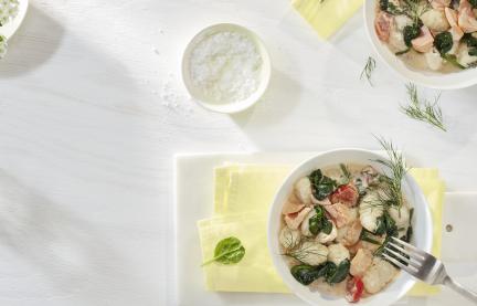 Gnocchi mit Lachs-Spinat-Sauce in zwei tiefen Tellern.