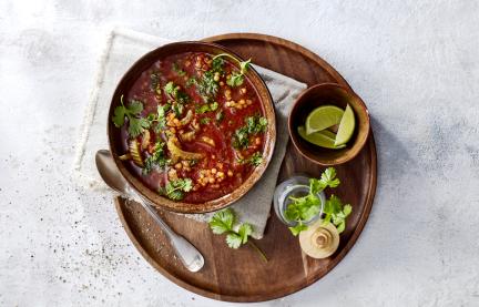 Vegane Linsen-Tomaten-Suppe in eine Schüssel.