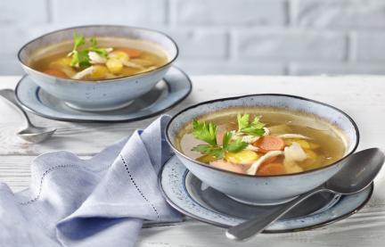 Hühnersuppe mit Gemüse in zwei Schalen.