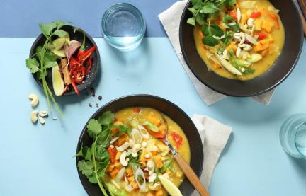 Gelbes Curry in zwei Schalen mit Koriander und Cashewkernen.