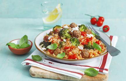 Reistopf mit Hackbällchen auf einem Teller, dekoriert mit einem Stofftuch