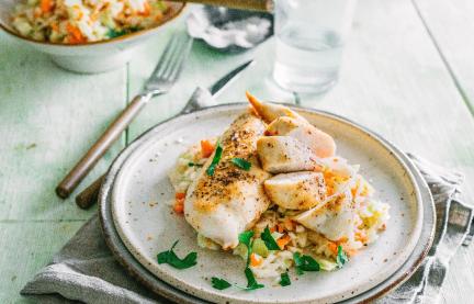 Gedämpftes Hähnchen mit Krautsalat serviert auf einem gedeckten Tisch.