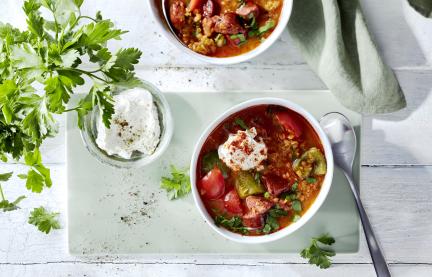 Spanische Linsensuppe mit Frischkäse in einer Schale.
