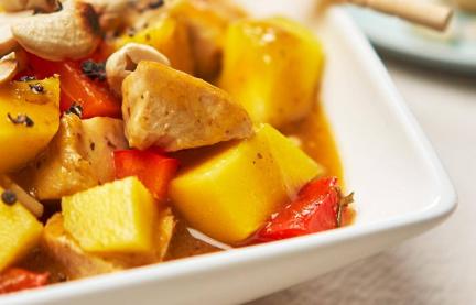 Hähnchen-Curry in Nahaufnahme auf einem eckigen weißen Teller