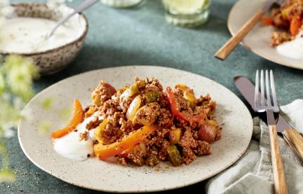 Arabisches Reiterfleisch mit Paprikastreifen auf einem hellen Teller angerichtet.