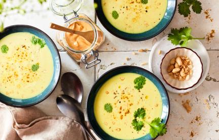 Kokossuppe in grünen Schüssel angerichtet.
