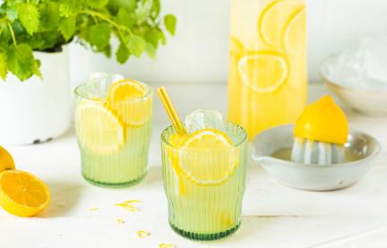 Zitronenlimonade mit Zitronenscheiben und Strohhalm in Gläsern.