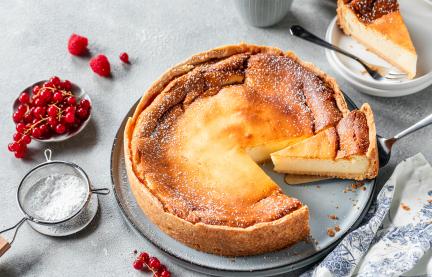 Klassischer Käsekuchen angeschnitten auf Tortenplatte
