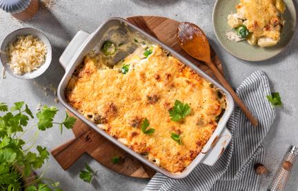 Rosenkohl-Kartoffel-Auflauf in einer hellen Form mit Petersilie getoppt.