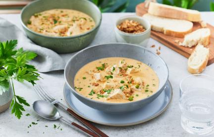 Pute in Senfsauve in zwei Schüsseln mit Kräutern dekoriert.