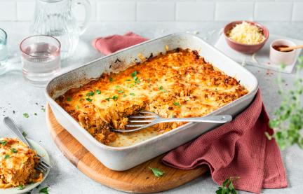 Weißkohlauflauf mit Käse überbacken in einer weißen Auflaufform.