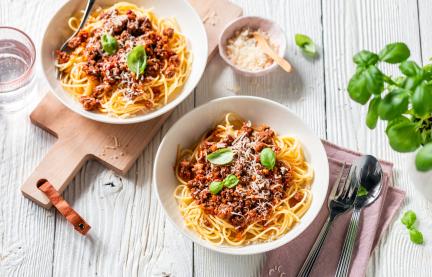 Einfache Spaghetti Bolognese auf Tellern garniert mit Basilikum