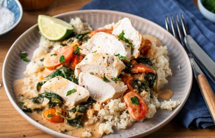 Parmesan Hähnchen mit Blumenkohlreis auf einem Teller.