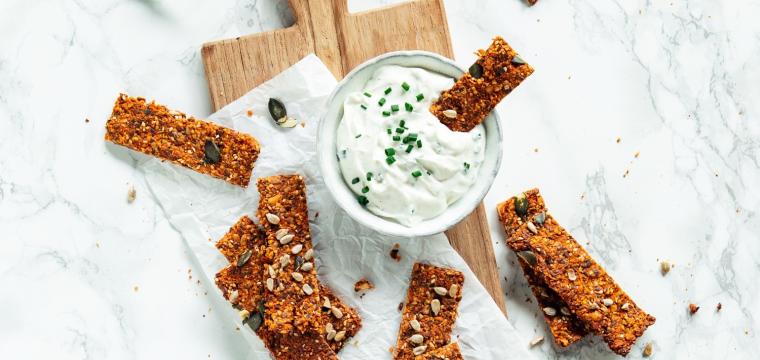 Mehrere Tomaten-Karotten-Cracker mit Pesto auf Schiefertafel. Mehrere Tomaten-Karotten-Cracker mit Pesto auf Schiefertafel.