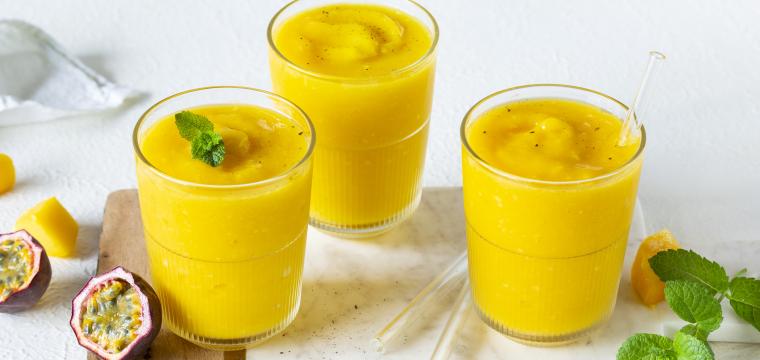 Mango-Maracuja-Slush serviert in drei Gläsern. Mango-Maracuja-Slush serviert in drei Gläsern.