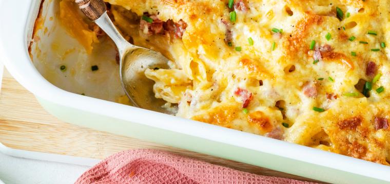 Cremiges Nudel-Schinken-Gratin auf Teller und in Auflaufform