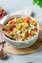 Bunter Quinoa Salat mit frischem Gemüse und Feta in einer Schüssel.