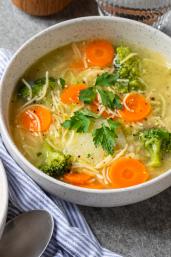 Frühlingssuppe mit buntem Gemüse in Schüsseln.