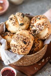 Selbstgemachte Brötchen mit Körnern und Samen in einem Brotkorb.