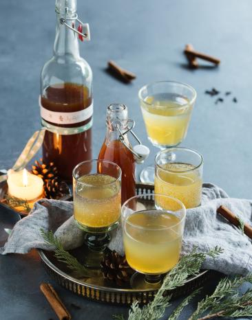 Apfel-Punsch-Sirup in einer Flasche und vier Gläsern