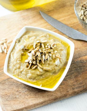 Auberginen-Joghurt-Dip in einer Schale mit Pinienkernen garniert.