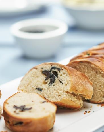 Aufgeschnittenes Baguette mit schwarzen Oliven