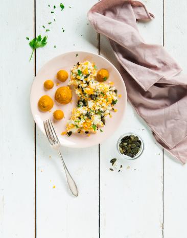 Blumenkohl-Couscous mit gespritzem Kürbispüree auf Teller