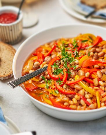 Bohneneintopf mit Paprika in einem Teller angerichtet.