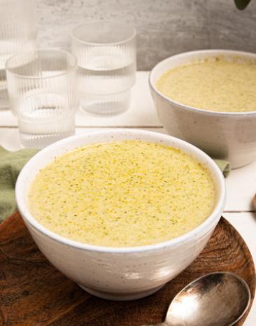 Brokkolicremesuppe in zwei Schalen auf einem Tisch.