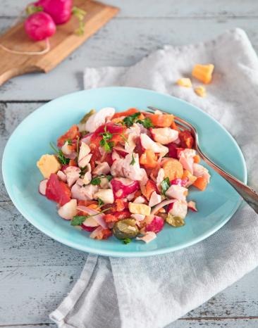Bunter Käse-Wurst-Salat auf einem Teller mit Gabel.