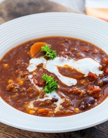 Chili mexikanisch in einem Suppenteller angerichtet.