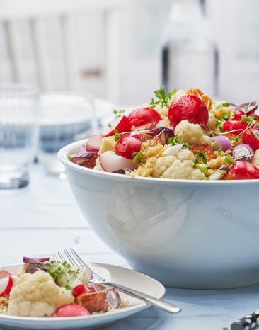 Couscous mit Blumenkohl und gebratenem Halloumi in einer Schüssel und auf einem Teller.