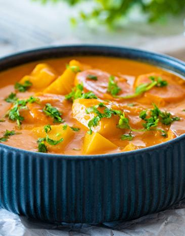 Curry mit Kartoffeln, Karotten und Kokosnuss in einer Schüssel.